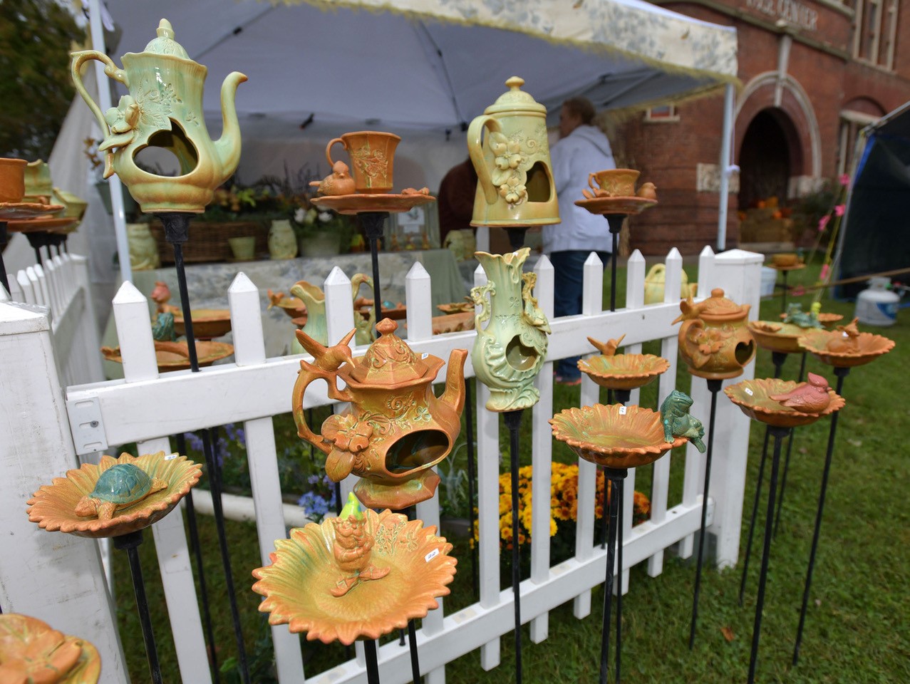 display of lawn ornaments in front of a picket fence