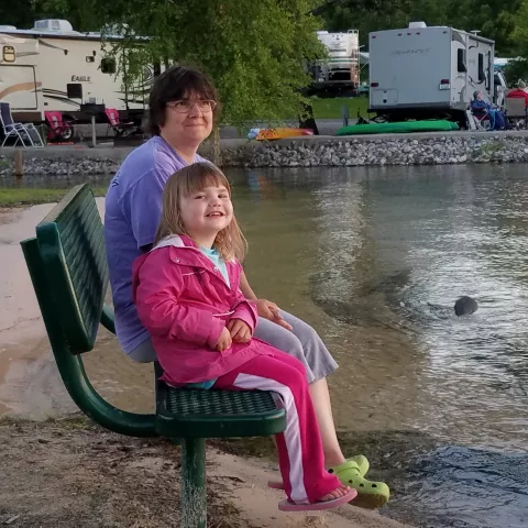 Family sitting at Lillydale beach with campground in the back