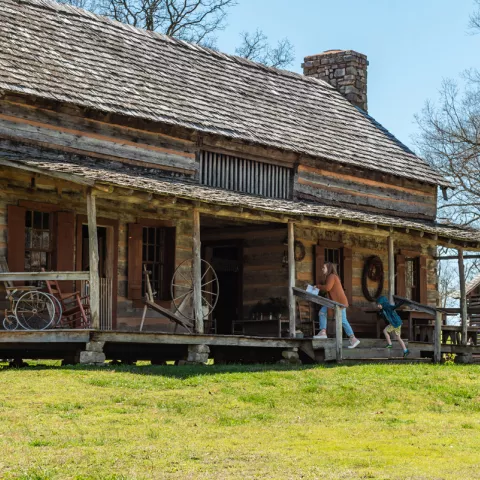visitors enter a large historic log home