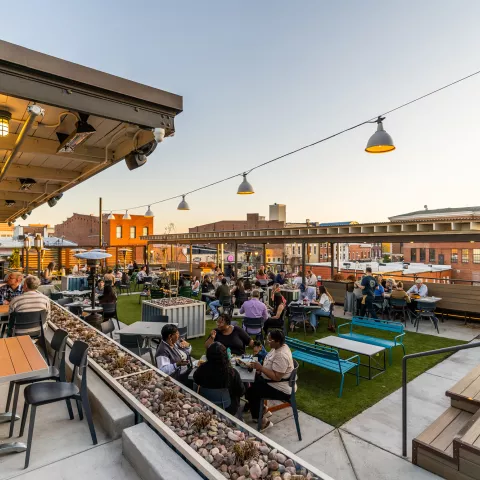 Guests dine on a large outdoor patio with a view of Historic Downtown Clarksville.