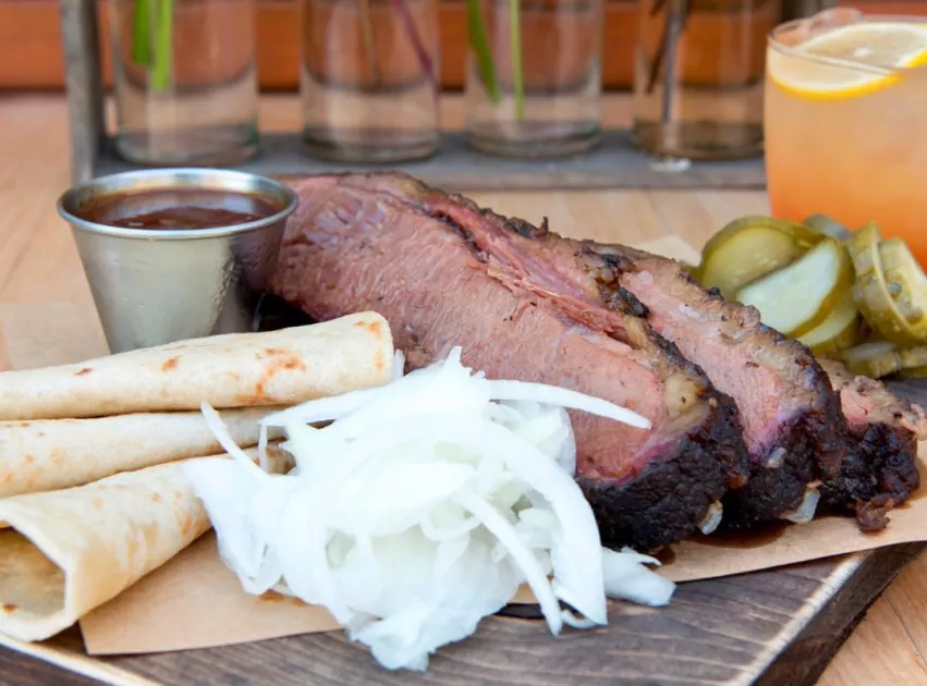 slices of brisket with slices of onion and tortillas
